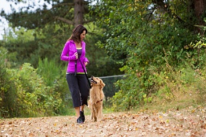 women walking a dog on a trail 