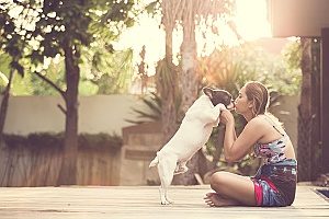 woman playing outside with her dog which is one of the best summer activities you can do with your dog