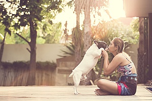 woman playing outside with her dog which is one of the best summer activities you can do with your dog
