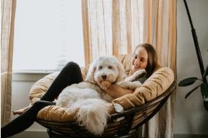 A female dog sitter sitting with a dog