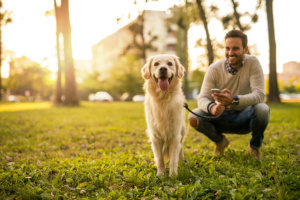 a man taking his dog for a stroll at the park