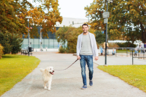 a man walking his dog that walks in circles in the park