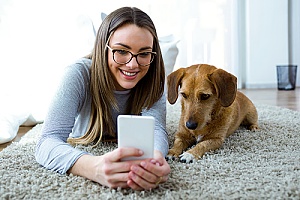 a woman with her dog using pet technology products