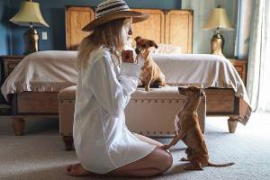 A woman training her dogs on how to stop a dog from urinating in a certain spot inside