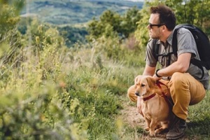 man in with his dog on a dog walking trail
