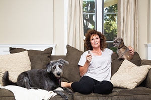 woman with two dogs on couch with treat