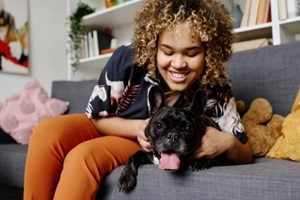 african young woman with curly hair happy to have a dog