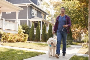 man taking dog for midday walk along Northern VA suburban street